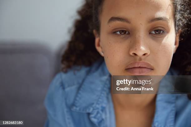 sad and unhappy teenager looking out of the window - 14 year old biracial girl curly hair stock pictures, royalty-free photos & images