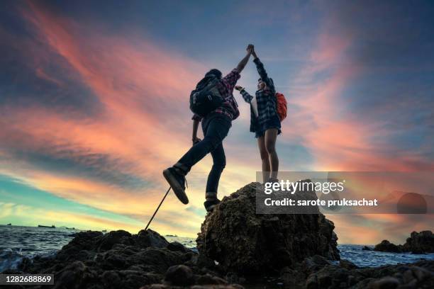 two climber helping to hike up . - bergsteiger gipfel stock-fotos und bilder