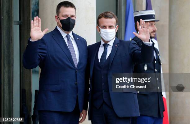 Estonia's Prime Minister Juri Ratas poses for pictures with French President Emmanuel Macron as he arrives for a meeting at the Elysee Presidential...