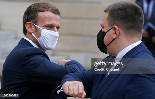 French President Emmanuel Macron elbow bumps Estonia's Prime Minister Juri Ratas following their meeting at the Elysee Palace on October 28, 2020 in...