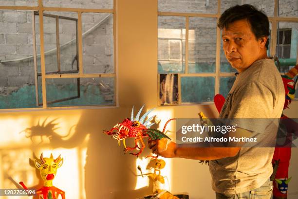 David Linares shows an alebrije during a day of work at David Linares Studio on October 27, 2020 in Mexico City, Mexico. David Linares is a Mexican...