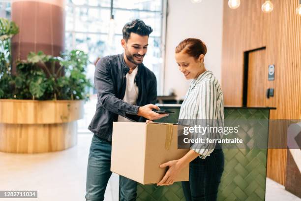 courier scanning package at office reception - picking up mail stock pictures, royalty-free photos & images