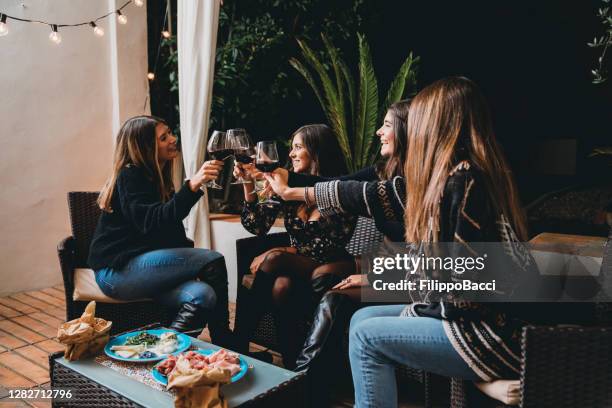 vrienden die samen met rode wijn tijdens een terrasdiner aperitief roosteren - opening night dinner stockfoto's en -beelden