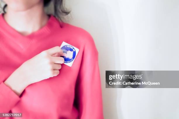 young mixed-race female holds “i voted” sticker - woman president stock pictures, royalty-free photos & images