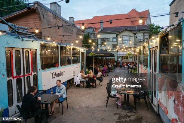 people enjoying summer evening in an outdoor cafe - riga stock pictures, royalty-free photos & images