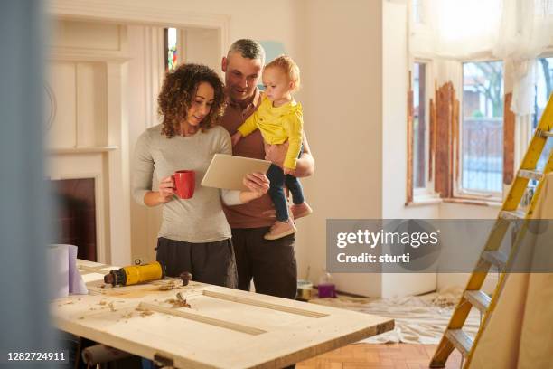 checking their house insurance - couple with ipad in home stock pictures, royalty-free photos & images