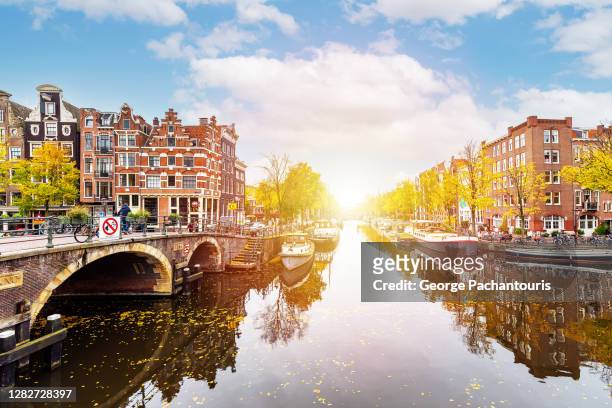 bright sun in a canal in amsterdam, holland - amsterdam dusk evening foto e immagini stock