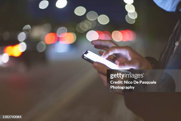 man using mobile phone outdoors - social media fotografías e imágenes de stock