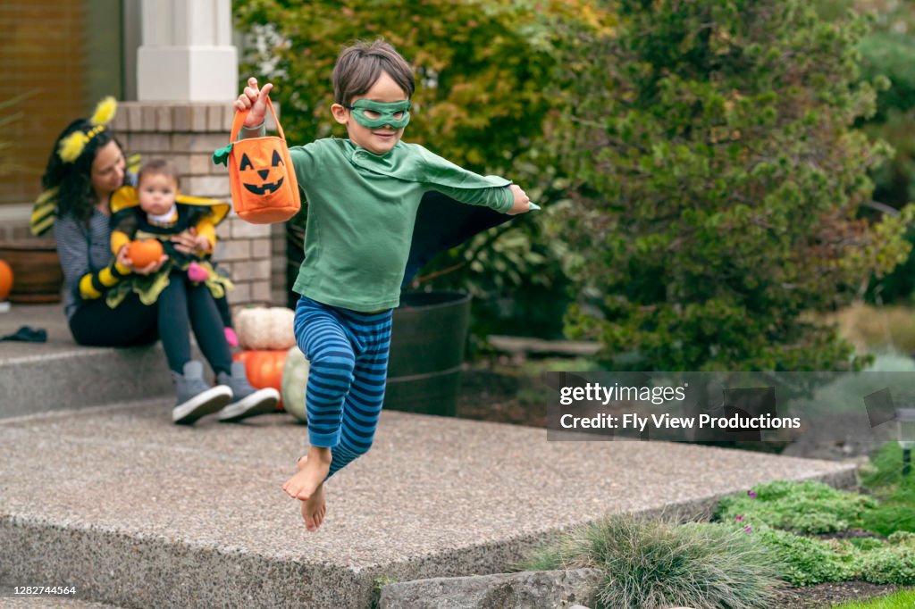 Happy boy on Halloween playing in his front yard