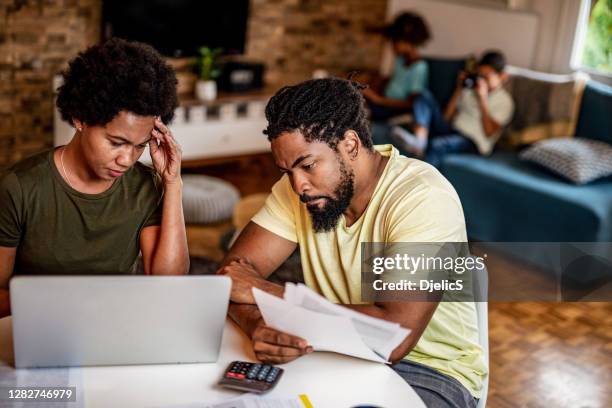 frustrated couple having bills to pay. - family budget stock pictures, royalty-free photos & images