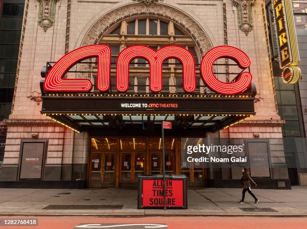 Person walks outside the AMC Empire 25 movie theater in Times Square as the city continues the re-opening efforts following restrictions imposed to...