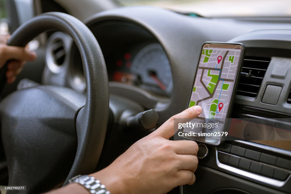 Bestuurder die GPS navigatie in mobiele telefoon gebruikt terwijl het drijven van auto