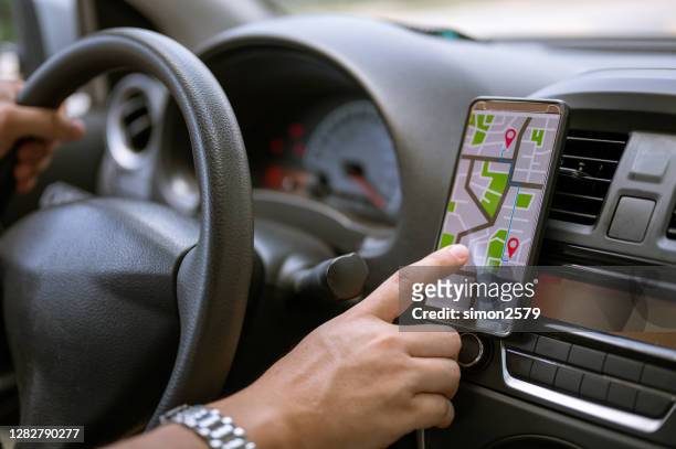 driver using gps navigation in mobile phone while driving car - sirius imagens e fotografias de stock