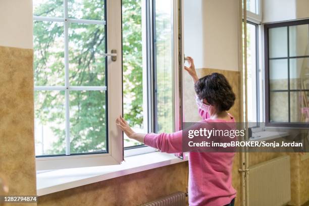 airing in a classroom, teacher opens window to air, austria - lüften stock-fotos und bilder