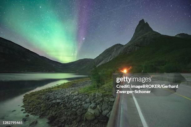 night shot of (aurora borealis) a road with illuminated entrance to the tunnel, starry sky, northern lights northern lights, in the back mountain top stetind, stetinden, nordland, norway - stetind stock pictures, royalty-free photos & images