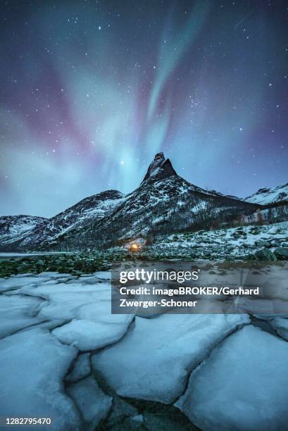mountain peak (aurora borealis) stetind, arctic winter landscape, night view, starry sky, northern lights northern lights, in front ice floes, stetinden, nordland, norway - stetind stock pictures, royalty-free photos & images