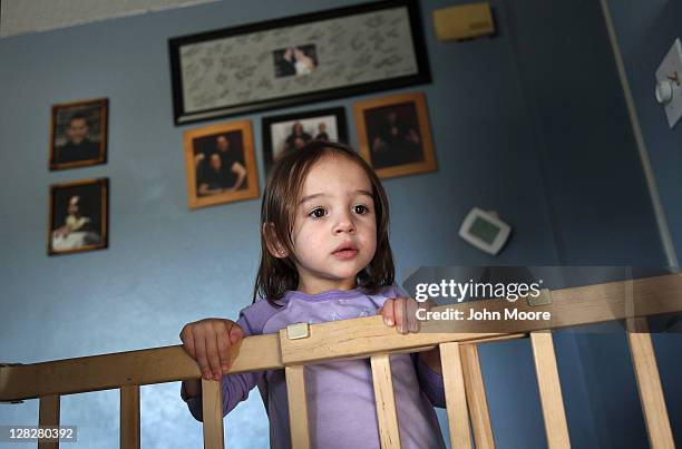 Caitlin Barbiere, 2 1/2, watches as an eviction team removes her family's household belongings during a home foreclosure on October 5, 2011 in...