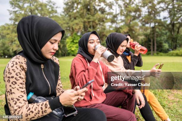 girls drinking water from water bottle - malay archipelago stock pictures, royalty-free photos & images