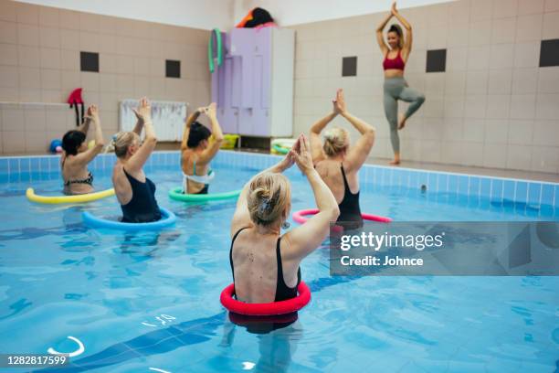 aktive seniorinnen in der aqua-aerobic-klasse - aquarobics stock-fotos und bilder