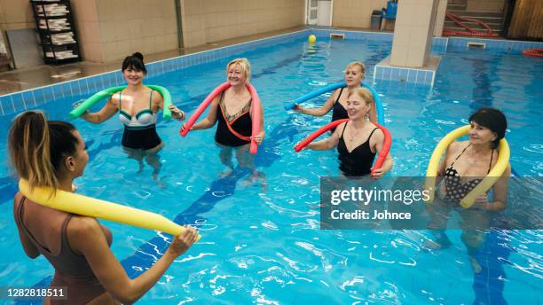 aktive seniorinnen in der aqua-aerobic-klasse - aquarobics stock-fotos und bilder