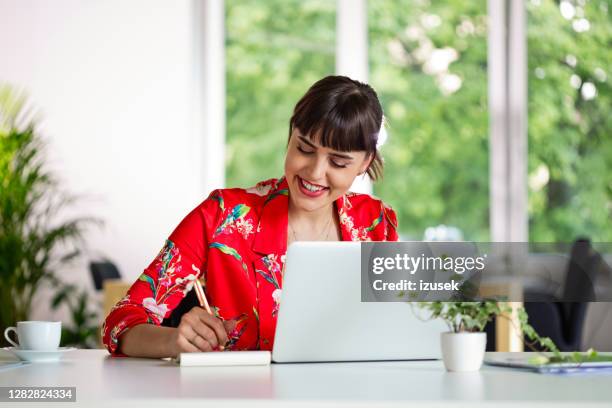 cheerful young woman working in the eco-friendly green office - blogging stock pictures, royalty-free photos & images