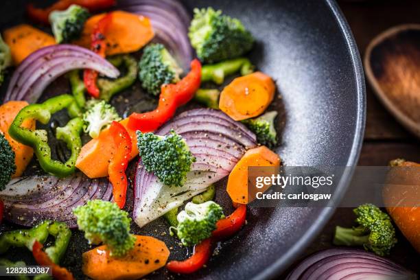 het koken van veganistisch voedsel op een koekenpan - sauteren stockfoto's en -beelden