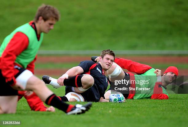 Flanker Dan Lydiate stretches with teammates during a Wales IRB Rugby World Cup 2011 training session at Newtown Park on October 6, 2011 in...