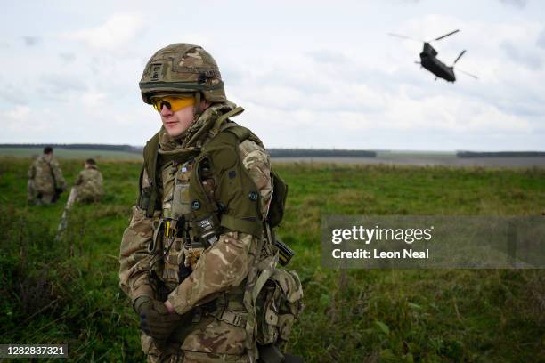 Soldier turns from the downblast of a CH-47 helicopter as it takes off during the UK Task Group Mission Rehearsal Exercise ahead of their deployment...