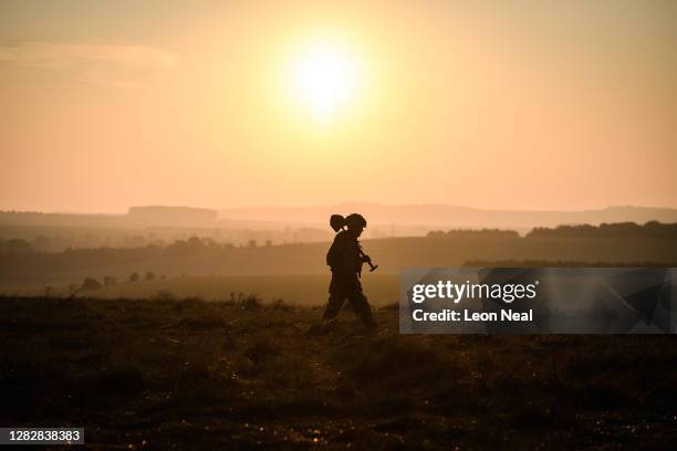 Soldier from the UK Task Group walks through the camp just after sunrise during a Mission Rehearsal Exercise ahead of deployment to Mali, on the...