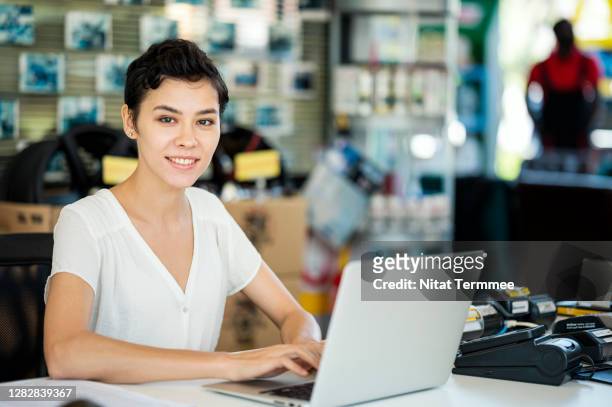 caucasian woman working at counter in auto repair center. customer service front desk. - motor vehicle department stock pictures, royalty-free photos & images