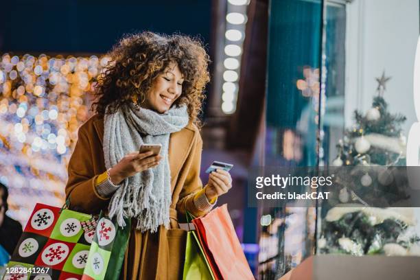 junge frau einkaufen für weihnachten - shopping credit card stock-fotos und bilder
