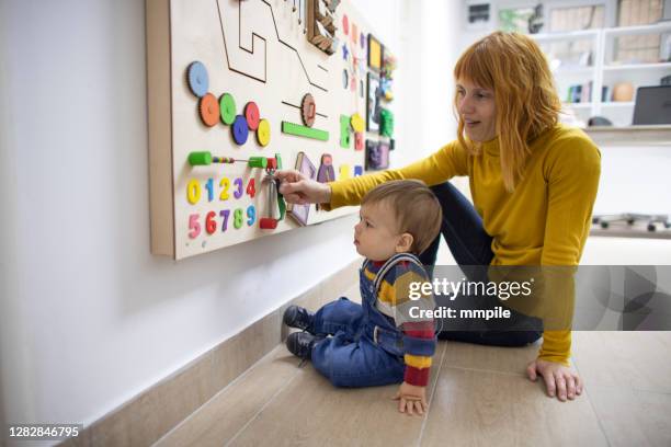 mom and her son playing with educational board - autism spectrum stock pictures, royalty-free photos & images