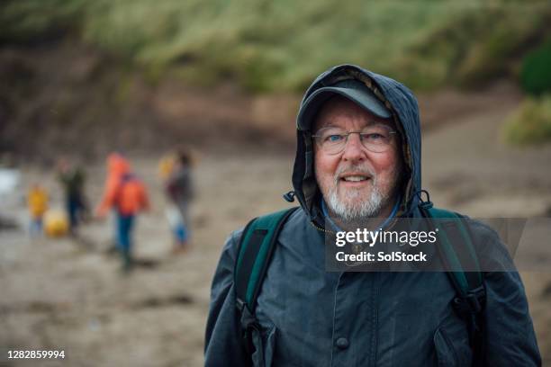 portrait of senior man on a day out at the beach - waxed jacket stock pictures, royalty-free photos & images