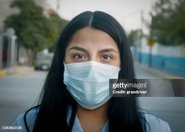 pretty mexicansk kvinna i ciudad juárez chihuahua mexiko nära den amerikanska gränsen justera sätta på att ta av sig n95 mask för att platta till kurvan och bromsa spridningen av covid-19 corona virus. - dykmask bildbanksfoton och bilder