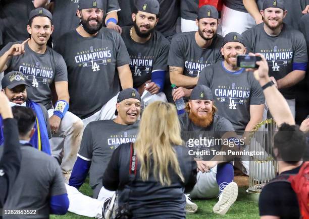 Justin Turner of the Los Angeles Dodgers and manager Dave Roberts of the Los Angeles Dodgers pose for a photo with their teammates after the teams...