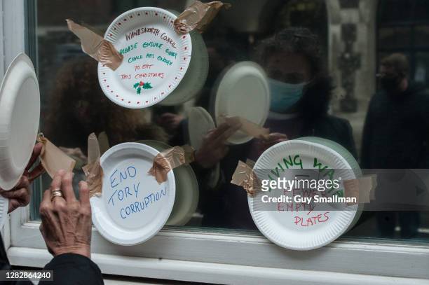 Paper plates are attached to the Department for Education building by members of the National Education Union and their supporters during a protest...