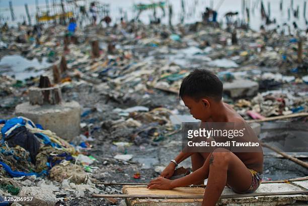 Young boy helps in rebuilding what's left of a shanty on the coastal community of Navotas town on October 6, 2011 in Manila, Philippines. The...
