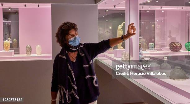 Curator Luísa Sampaio wears a protective mask while as she stands by glass works while briefing journalists on a press visit to the "René Lalique e a...