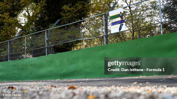 Tribute to Ayrton Senna hangs from the catch fence at the site of his fatal crash at Tamburello corner during previews ahead of the F1 Grand Prix of...