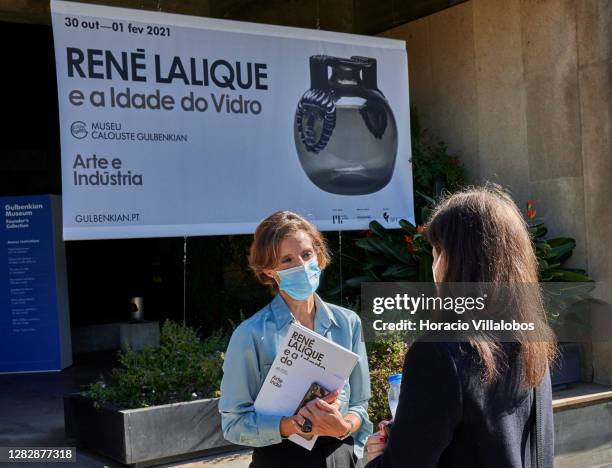 Masked museum staffer wears a protective mask as she greets a visiting journalist at the "René Lalique e a Idade do Vidro, Arte e Indústria" during...