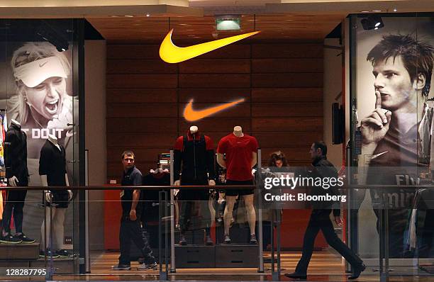 Posters of Andrey Arshavin, right, a footballer, and Maria Sharapova, left, a tennis player, sit in the window of a Nike Inc. Store at the Afimall...