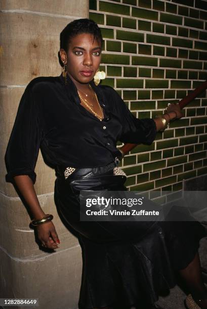 American R&B singer and actress Alyson Williams wearing a black blouse and a black leather skirt, posing on a stairwell, location unknown, circa 1995.