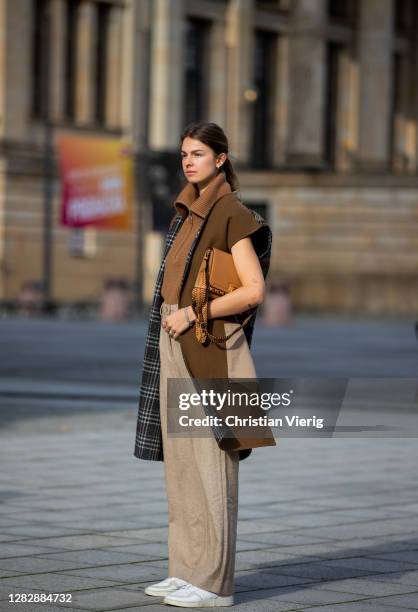 Jacqueline Zelwis is seen wearing brown Max Mara vest, Arket knit with zipper, Holzweiler pants, Adidas sneaker, beige Salvatore Ferragamo bag on...