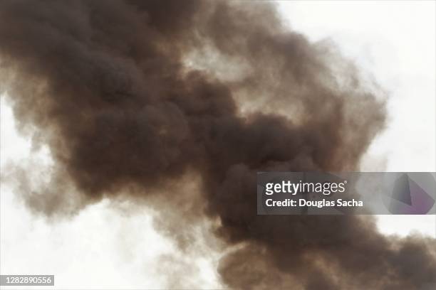 sky filled with black smoke - black smoke stock-fotos und bilder