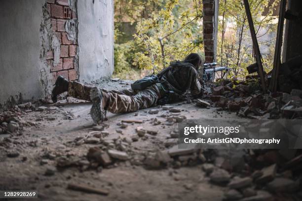 soldado oculto con francotirador de rifle en el edificio. - francotirador fotografías e imágenes de stock