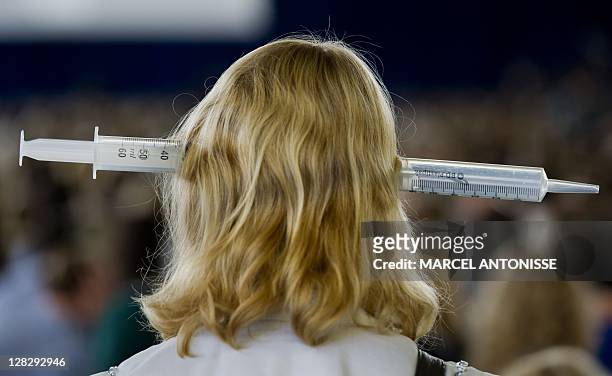General practitioner with a large syringe on her head takes part in a demonstration by approximately 5000 general practitioners and doctors'...