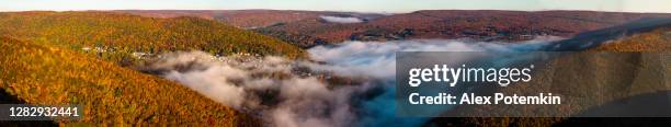low clouds fulfilling the valley between mountains over the historical town jim thorpe in the colorful autumn season in a sunny early morning. pocono region, carbon county, pennsylvania, usa. extra-large high-resolution aerial stitched panorama. - mount pocono pennsylvania stock pictures, royalty-free photos & images