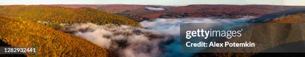 low clouds fulfilling the valley between mountains over the historical town jim thorpe in the colorful autumn season in a sunny early morning. pocono region, carbon county, pennsylvania, usa. extra-large high-resolution aerial stitched panorama. - montanhas pocono imagens e fotografias de stock