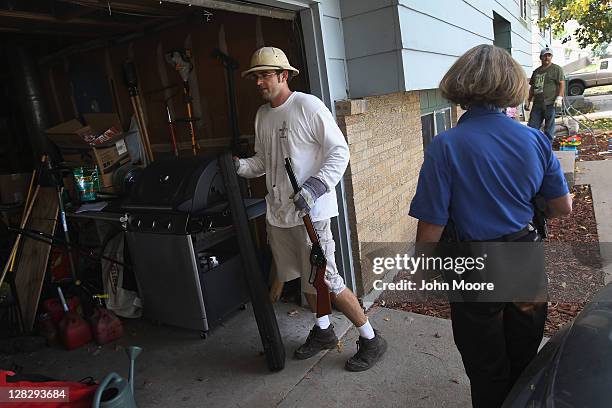 Eviction team leader Steve Fisser removes guns to the garage during a home foreclosure eviction on October 5, 2011 in Milliken, Colorado. Homeowner...