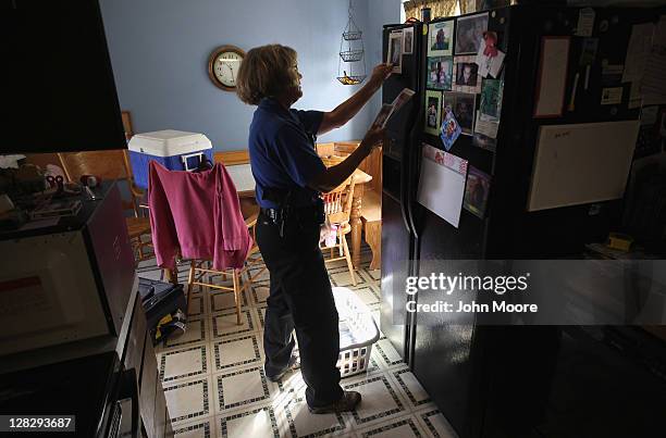 Weld County sheriff's deputy Mary Schwartz collects family photos during a home foreclosure eviction on October 5, 2011 in Milliken, Colorado. The...